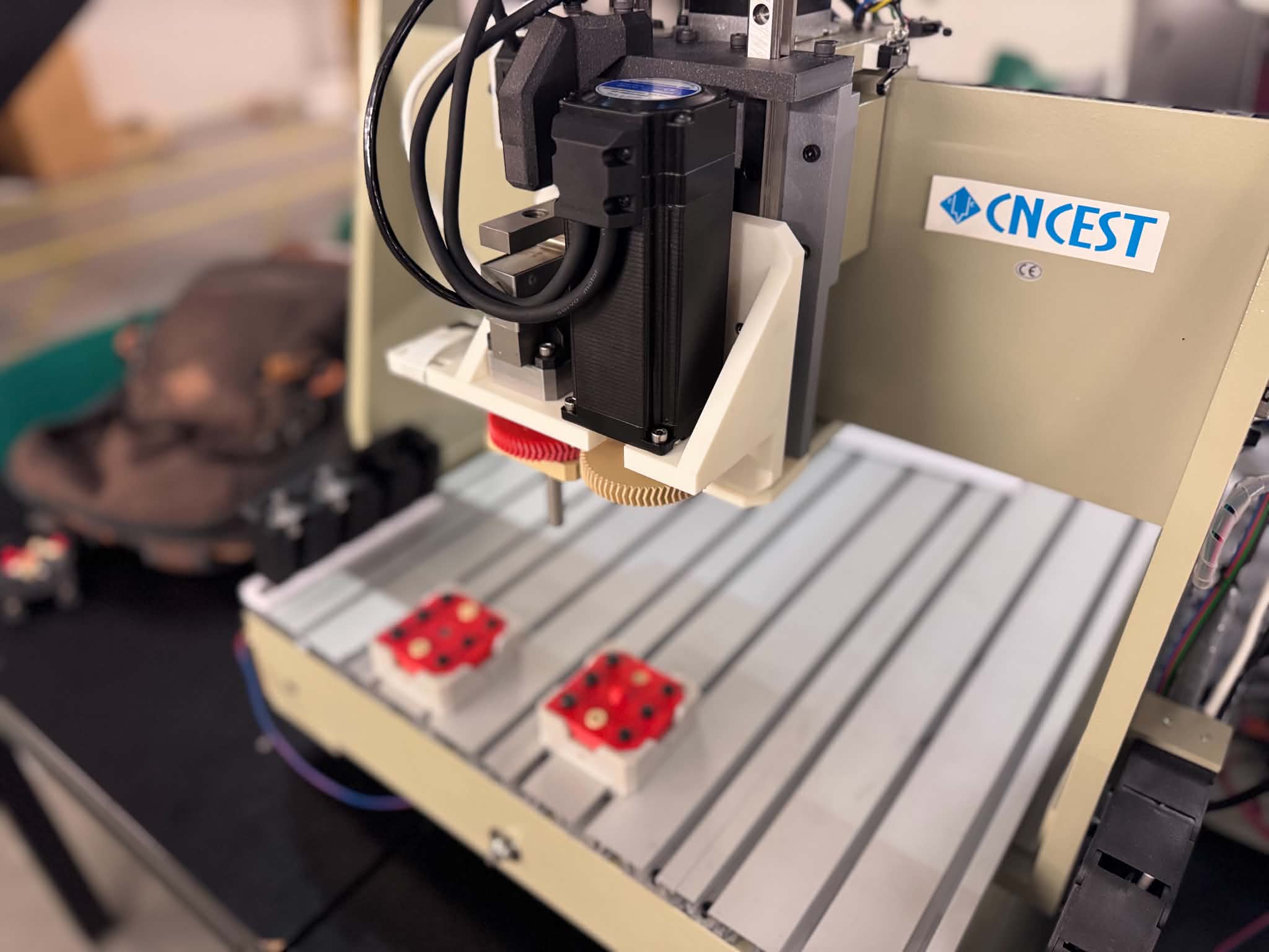 Gantry machine tool head over the work bed with 3D-printed test objects